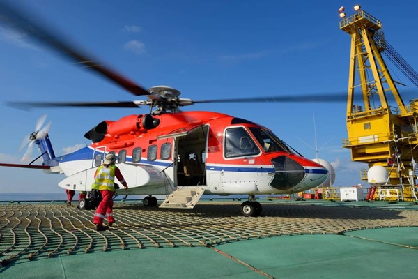 Helicóptero en primer plano sobre plataforma metálica. Al fondo, el mar, el cielo y el horizonte.