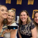 Cinco empleadas de BCD sonríen mientras muestran a la cámara el galardón a la empresa número uno de Reino Unido e Irlanda, en los Inspiring Workplaces Awards (Londres).