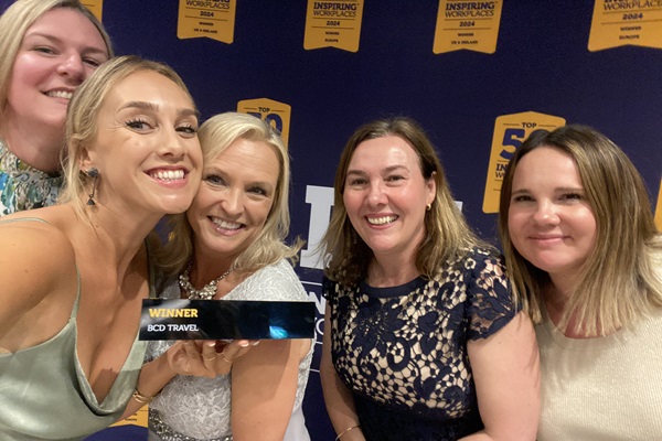 Cinco empleadas de BCD sonríen mientras muestran a la cámara el galardón a la empresa número uno de Reino Unido e Irlanda, en los Inspiring Workplaces Awards (Londres).