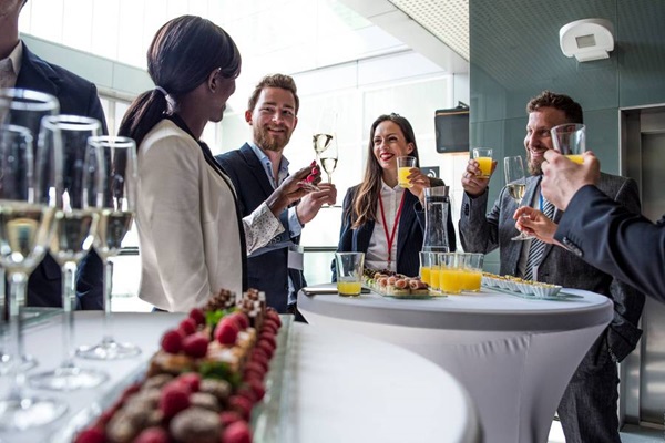 Dos mujeres y dos hombres de negocios brindan en un evento corporativo.