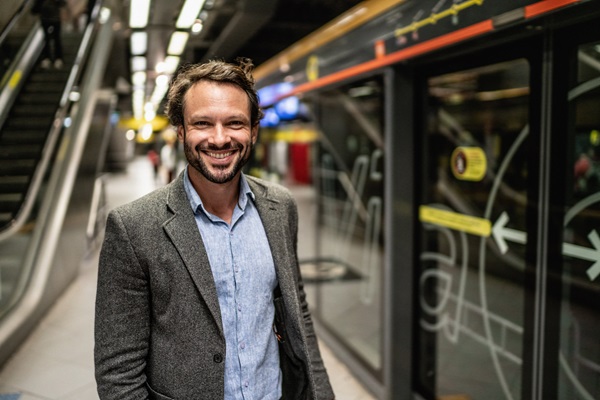 Hombre sonriendo en una estación de metro.