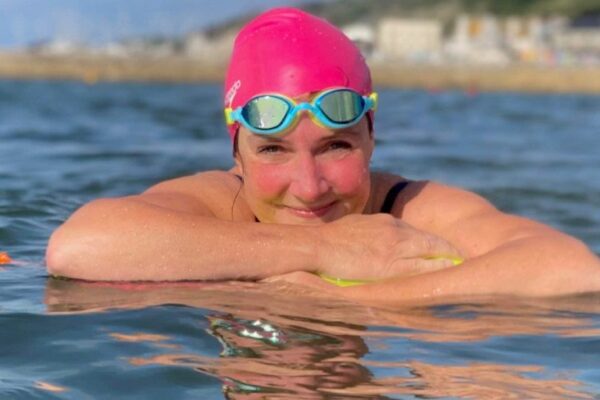 Claire Stephens, vice-présidente de BCD Travel, se jette à l'eau lors d'un entraînement de natation en eau libre.