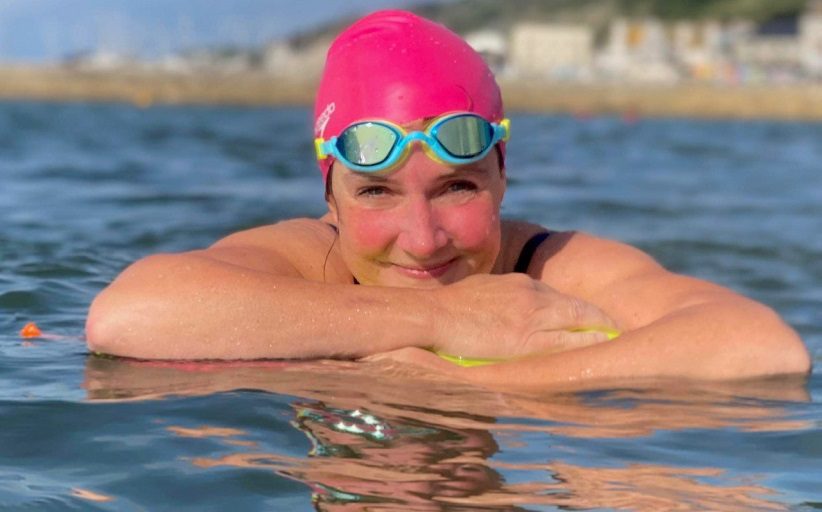 Claire Stephens, vice-présidente de BCD Travel, se jette à l'eau lors d'un entraînement de natation en eau libre.