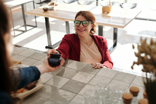 Donna paga con carta di credito al bar