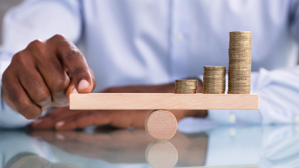 Balance concept with coins on a seesaw.