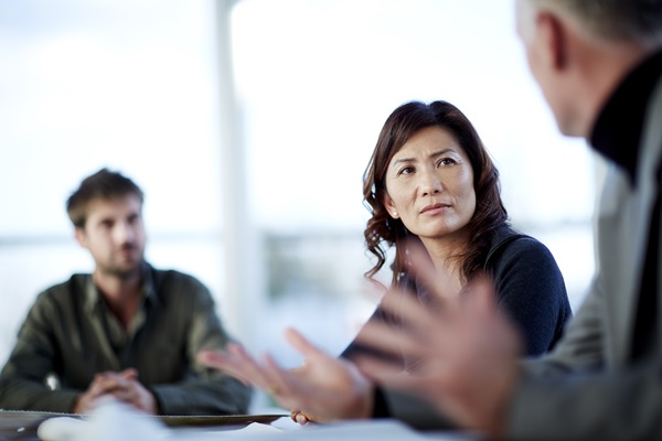 Three people engaged in serious conversation.