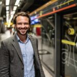 Man smiling in a subway station.